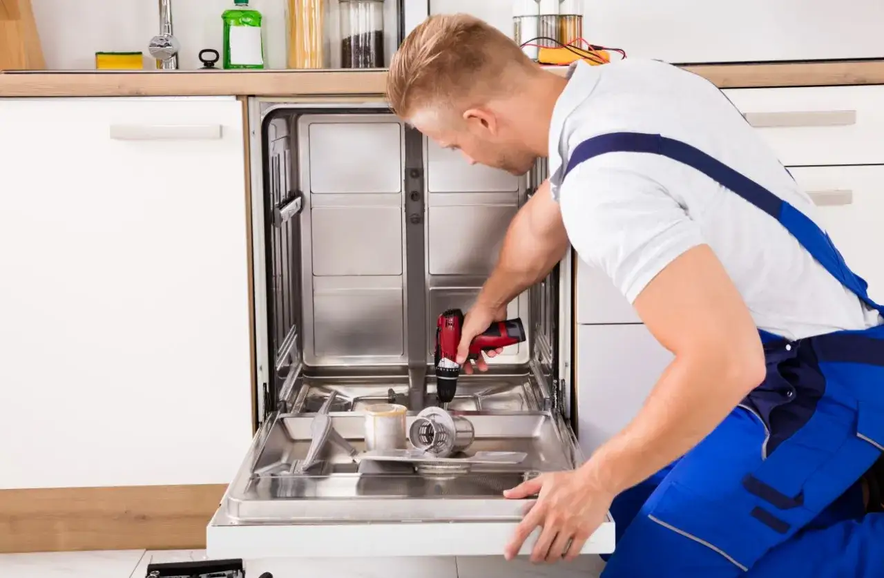 Technik montuje front do zmywarki Whirlpool, używając wkrętarki.