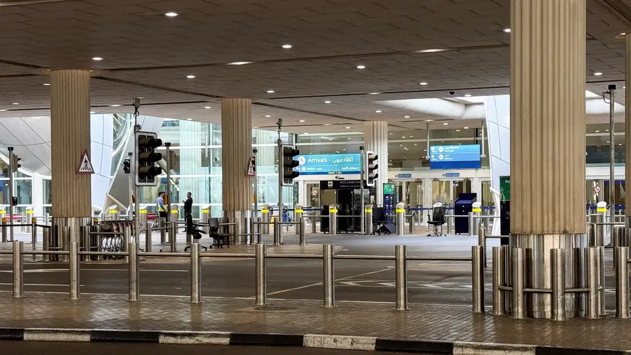 Puste lotnisko w Dubaju, oznaki "Arrivals" i sygnalizacja świetlna. Koronawirus w Dubaju wpłynął na ruch lotniczy.