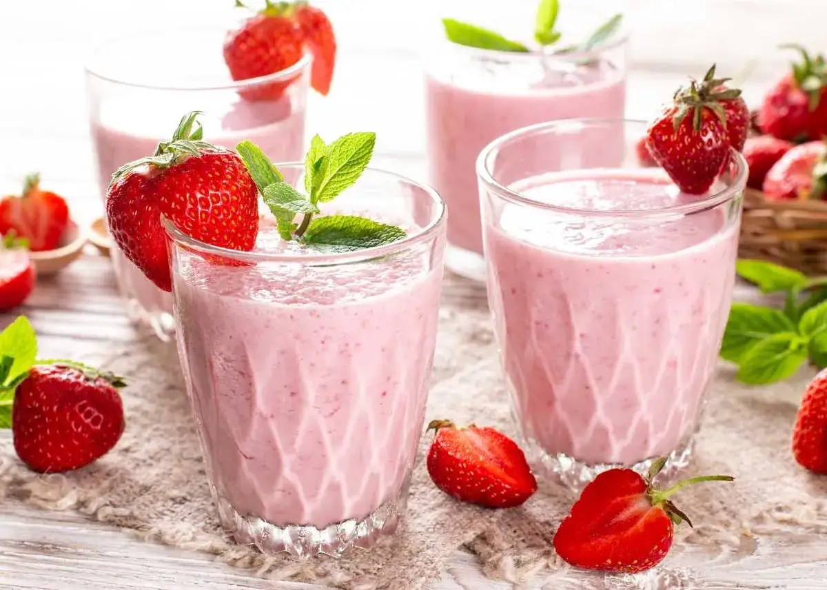 Batidos de fresa en vasos con fresas frescas y hojas de menta.