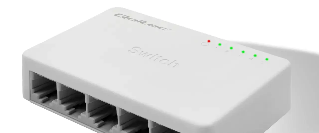 Biały, kompaktowy switch sieciowy z pięcioma portami RJ45 i diodami sygnalizującymi aktywność.
