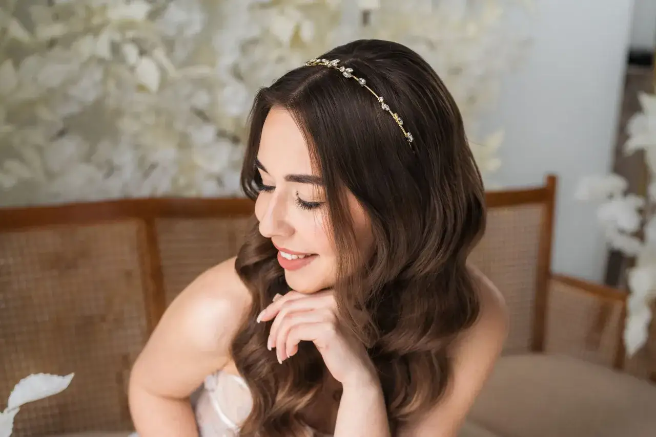 Delikatna tiara ślubna Swarovski zdobi włosy brunetki, dodając blasku jej ślubnej stylizacji.