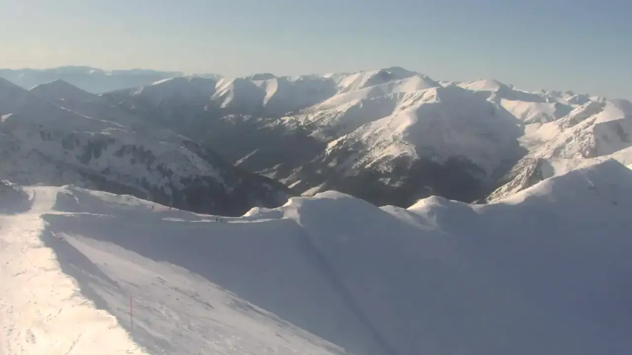 Widok z kamery na Kasprowy Wierch w Zakopanem. Ośnieżone szczyty Tatr i trasa narciarska.