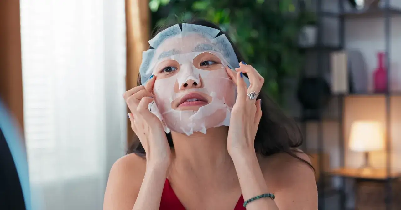 Kobieta poprawia maseczkę na noc, przygotowując skórę do regeneracji.