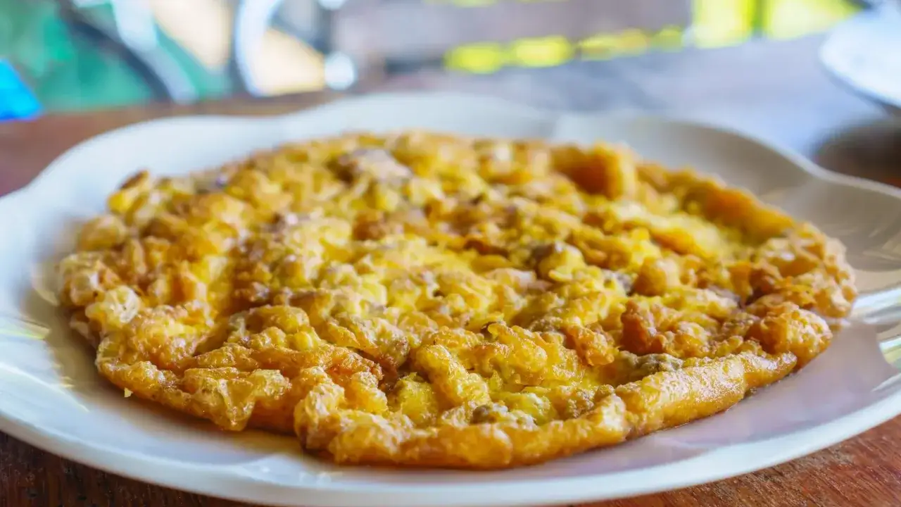 Złocisty omlet na białym talerzu, idealny omlet na kolację.