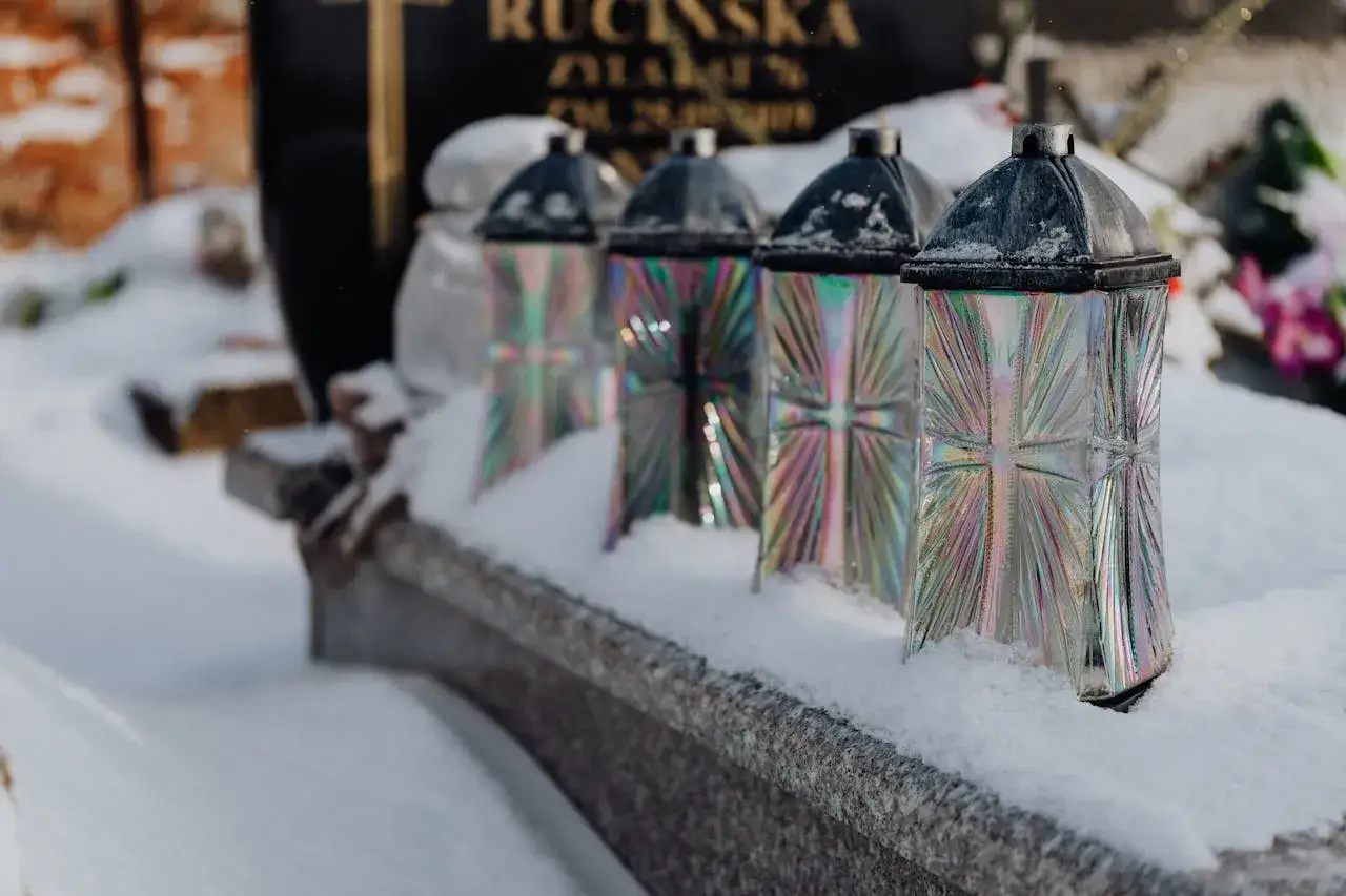 Znicze na grobie w śniegu. Czas zadumy i refleksji, ile trwa pogrzeb, gdy serce krwawi.