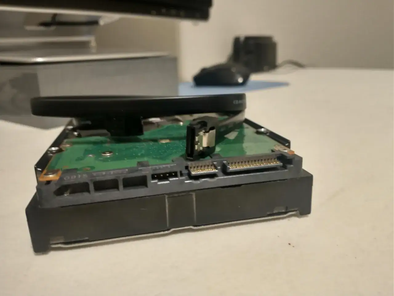 Dysk twardy z widocznym złączem **wejście SATA** i kablem zasilającym.