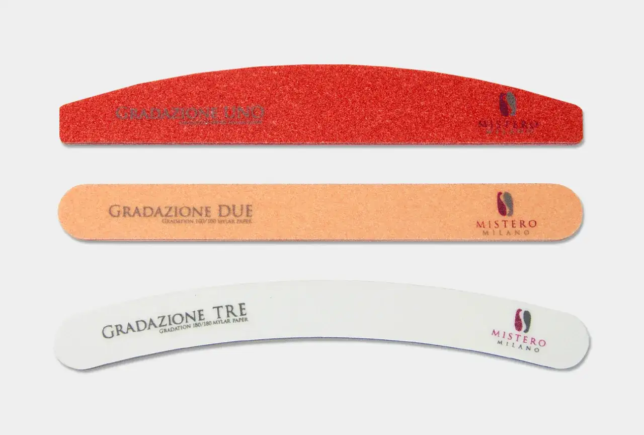 Trzy pilniki do paznokci: czerwony, pomarańczowy i biały, każdy z innym rodzajem gradacji.