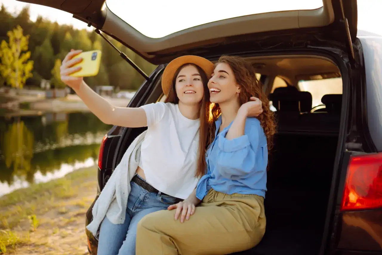 Dwie przyjaciółki robią selfie podczas babskiego wypadu nad jeziorem.