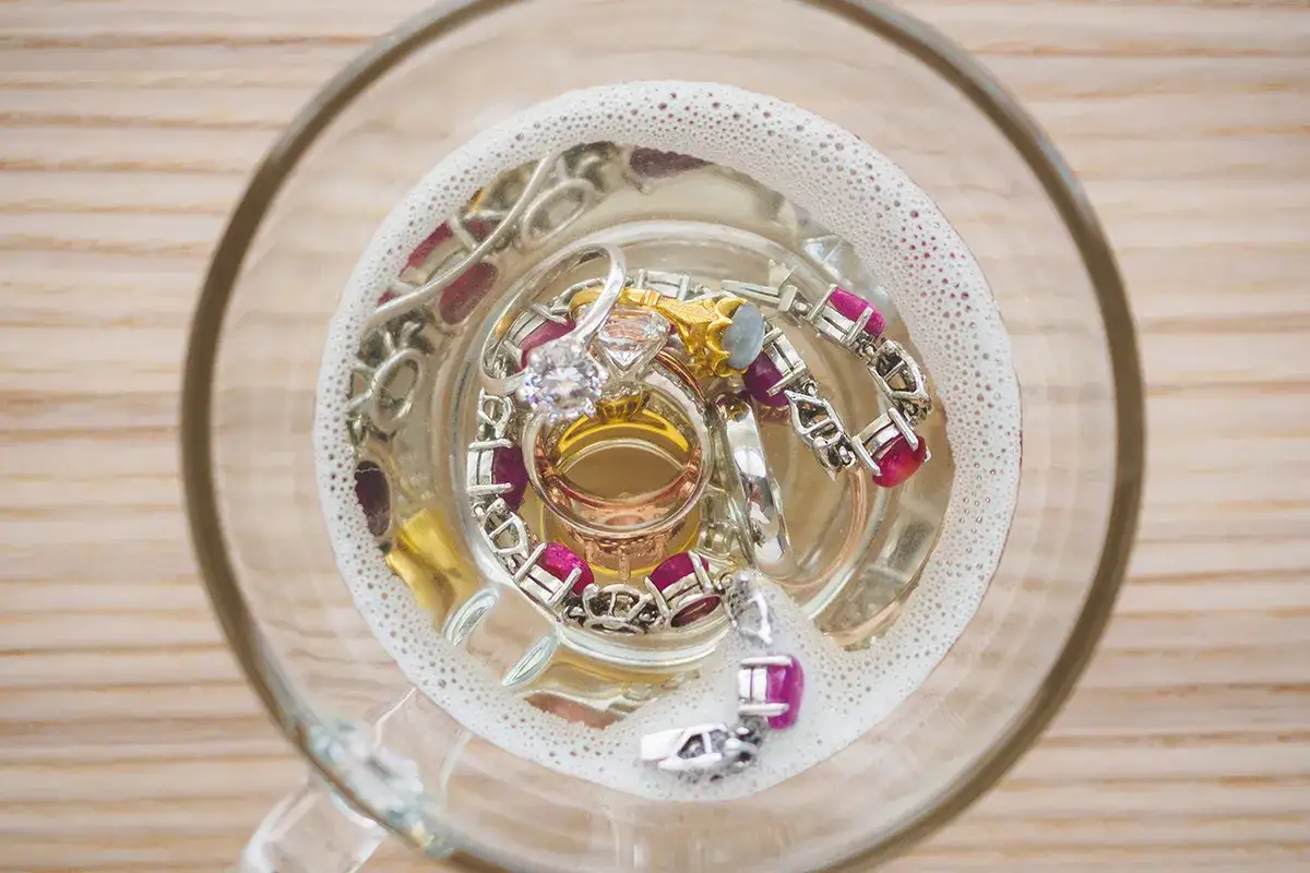 Biżuteria w szklanej misce z wodą i pianą.