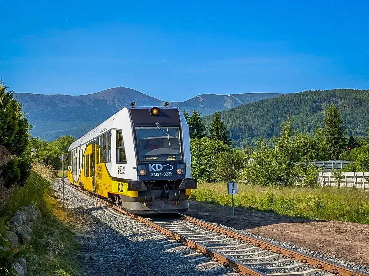 Pociąg KD jedzie przez malownicze tereny Karkonoszy. Dowiedz się, jak dojechać do Karpacza pociągiem i podziwiać te widoki!