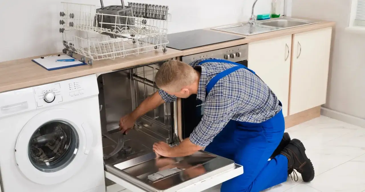 Serwisant naprawia zmywarkę Bosch, która wyświetla błąd E15. Widać też pralkę i kosze na naczynia.