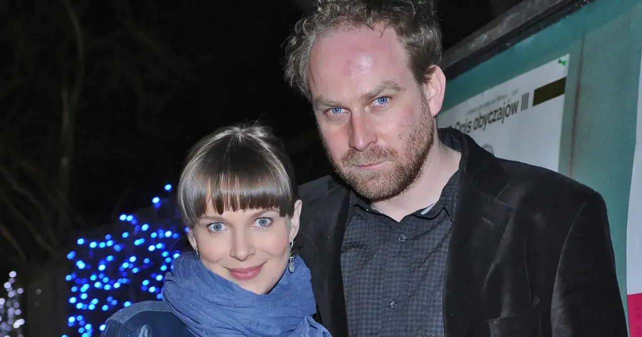 Marcin Perchuć i jego partnerka, uśmiechnięci na tle niebieskich światełek.