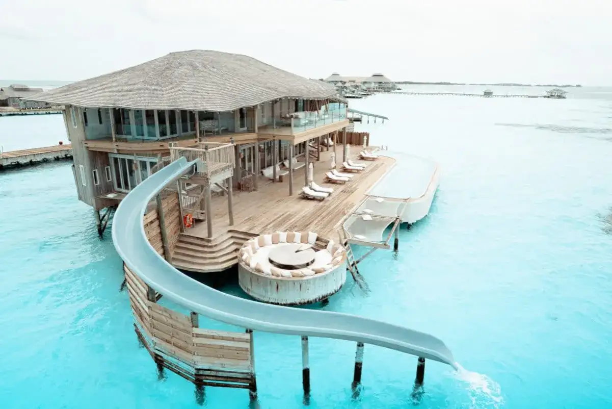 Malediwy: luksusowe domki na wodzie z prywatną zjeżdżalnią do turkusowej laguny. Idealne miejsce na relaks i zabawę.