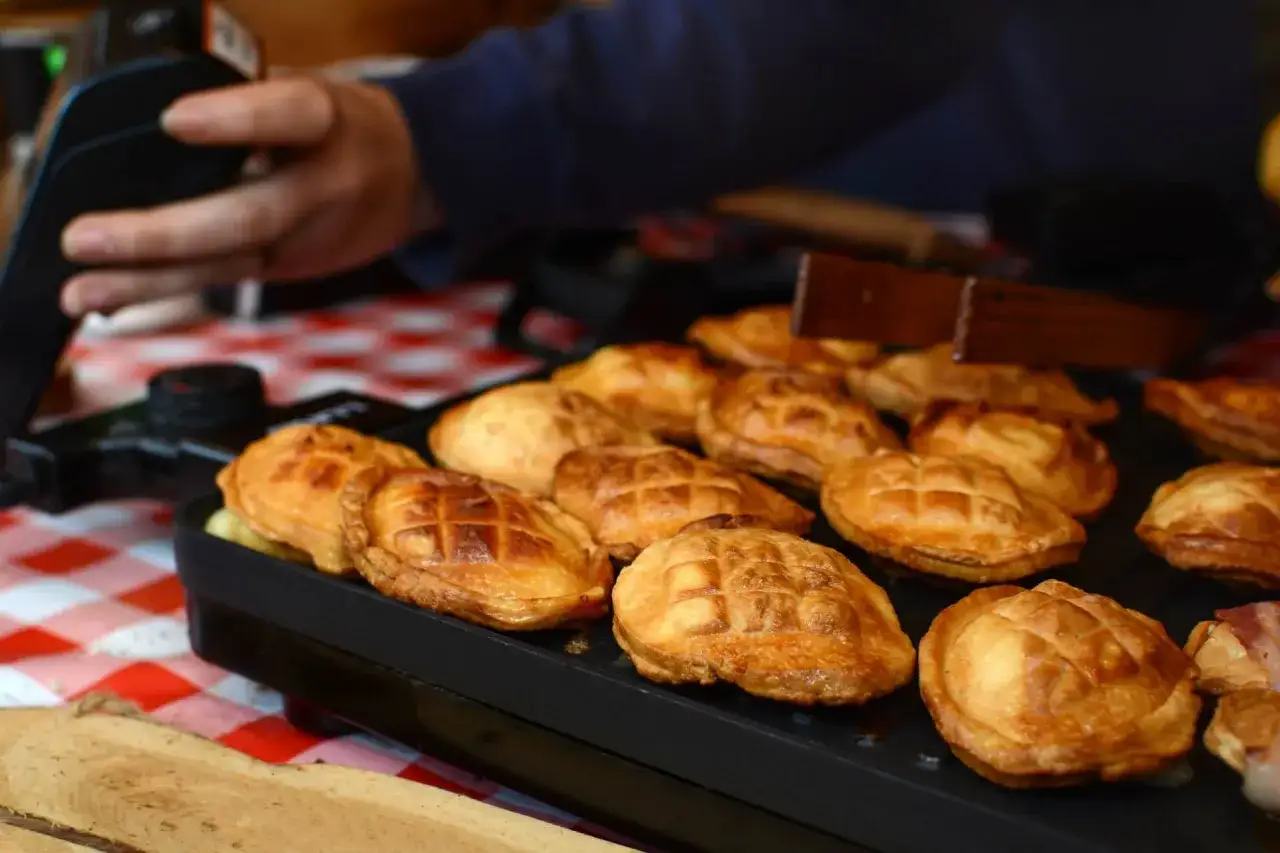 Złociste oscypki z grilla, idealne na górską gościnę na wierchu. Ręka sięga po kolejny przysmak.