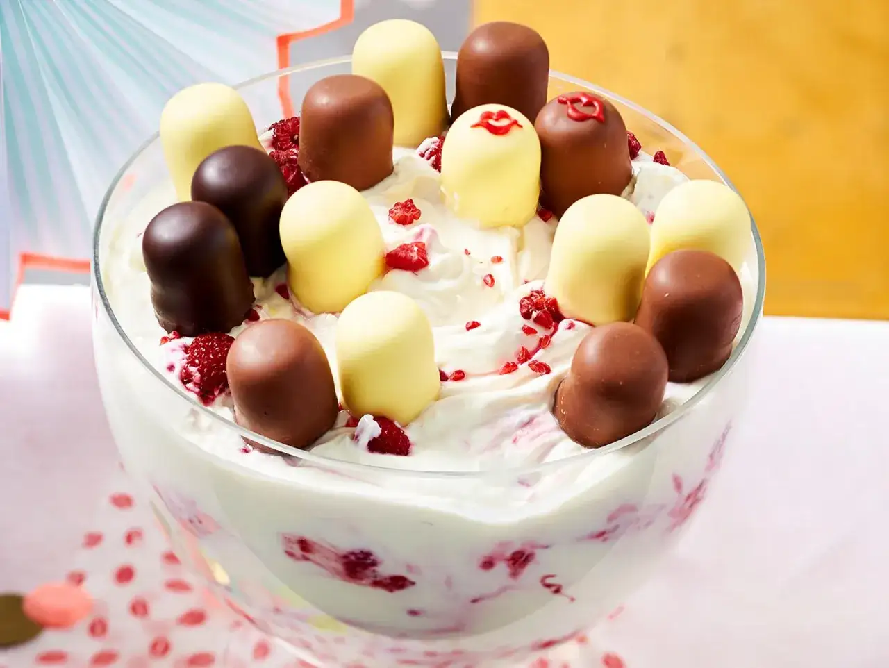 Schokoladen- und weiße Schaumküsse auf einer cremigen Nachspeise mit Himbeeren in einer Glasschüssel.