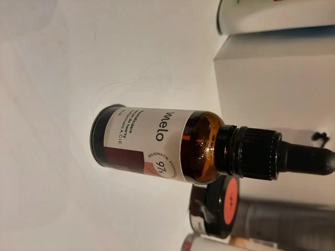 Butelka serum Melo z pipetą, z etykietą "97% składników pochodzenia naturalnego".