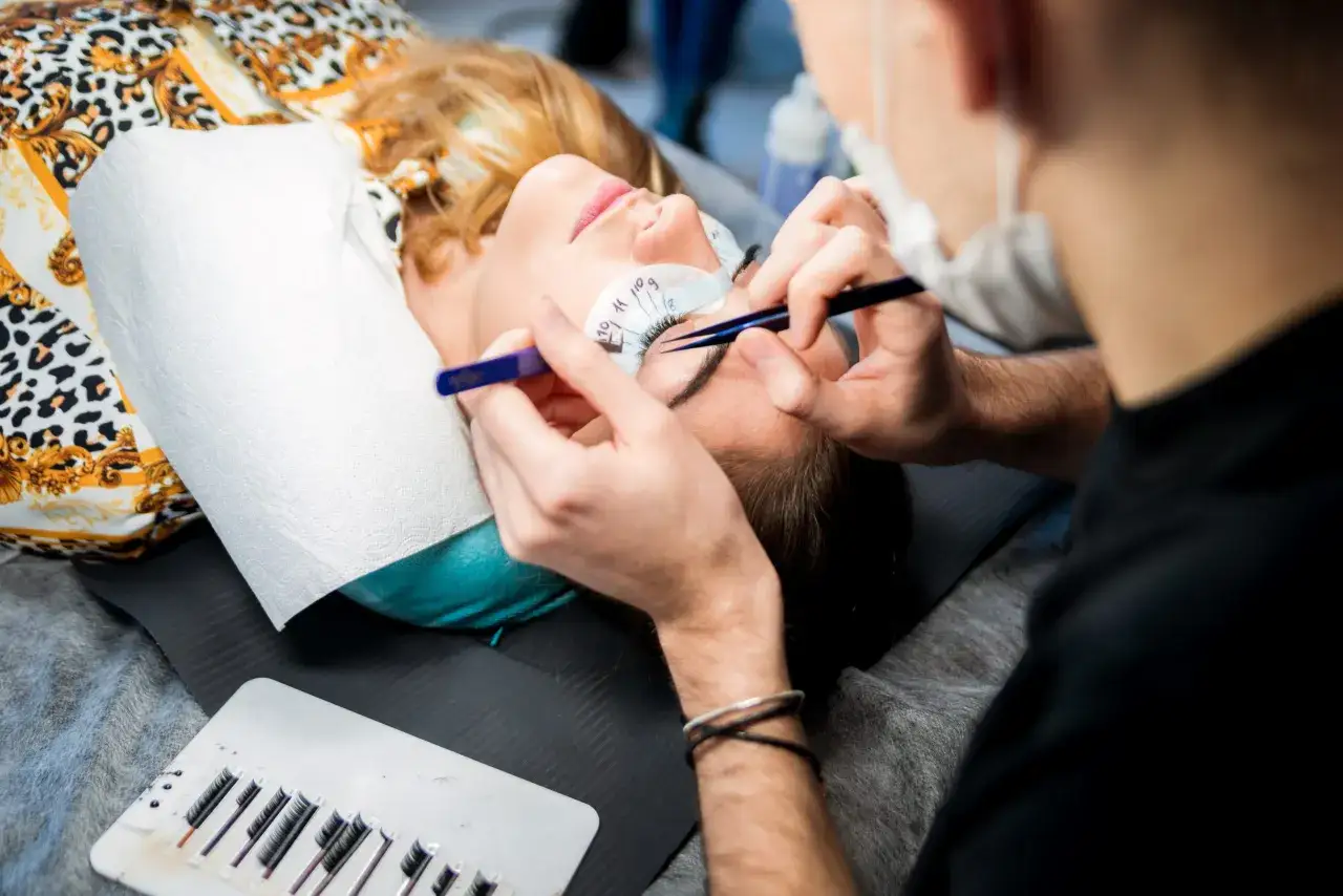Profesjonalny kurs przedłużania rzęs, gdzie najlepiej? Stylistka precyzyjnie dokłada kępki.