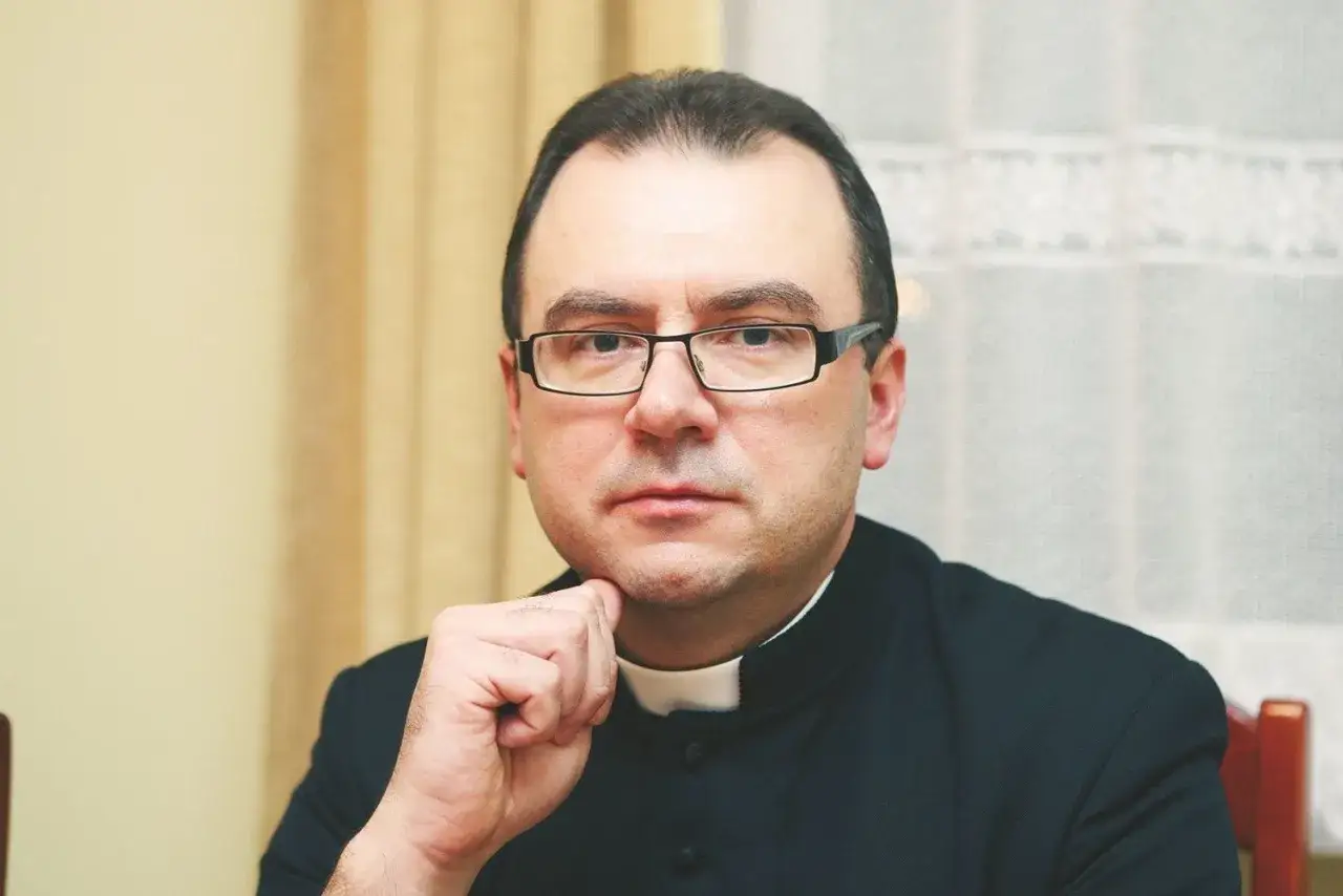Duchowny w okularach zamyślony, zastanawia się, czy po przeklinaniu można iść do komunii.