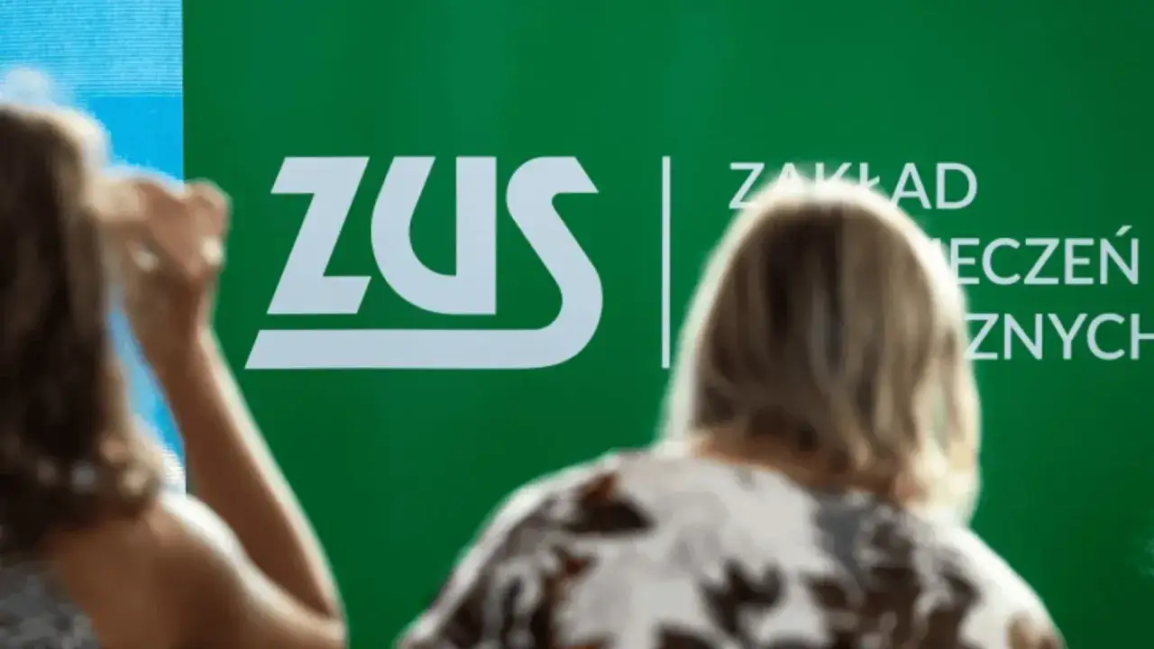 Ludzie przed zielonym banerem ZUS. Dyskusja o składce zdrowotnej 2026.