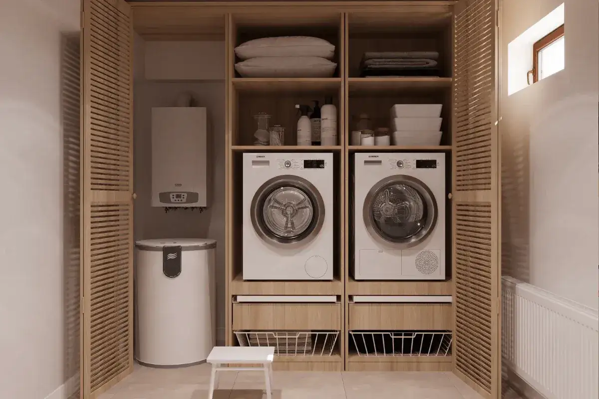Nowoczesna pralnia w domu: dwie pralki, suszarka, bojler i schowki na akcesoria. Drewniane fronty szafek nadają ciepła.