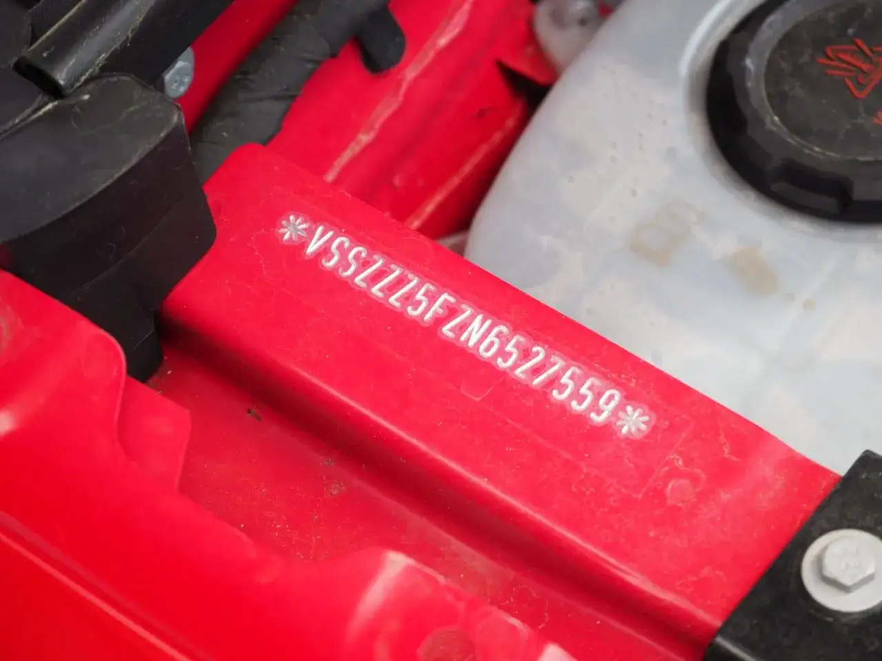 Numer VIN wybity na czerwonej belce samochodu.