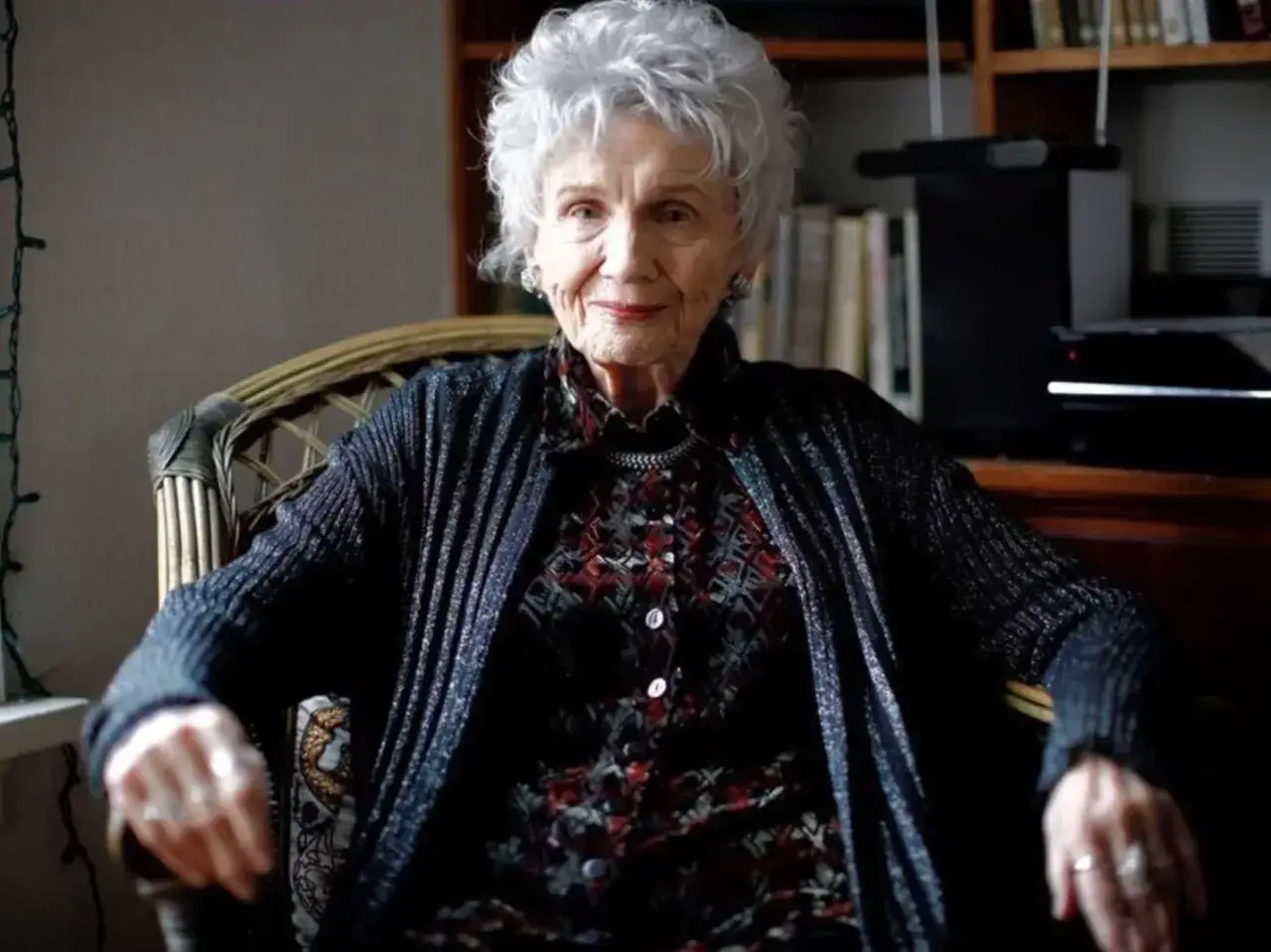 Portret starszej kobiety, kanadyjskiej pisarki noblistki Alice Munro, siedzącej w fotelu.