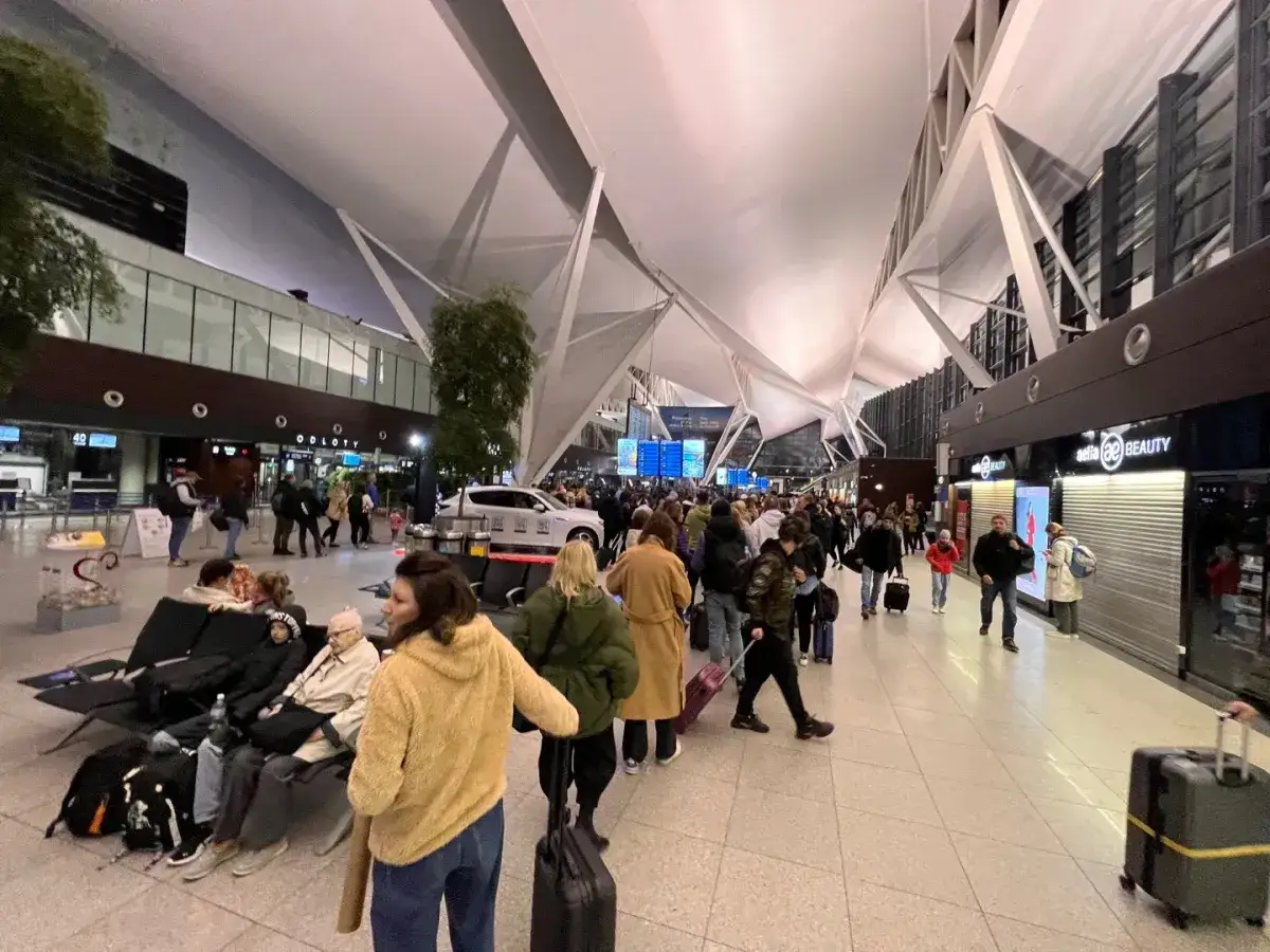 Tłum ludzi czeka na lotnisku w Gdańsku. Zastanawiasz się, ile przed odlotem powinieneś być na lotnisku?