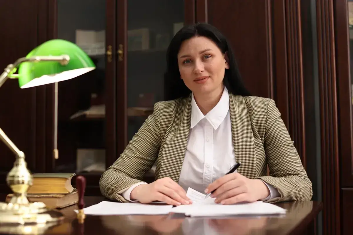 Radca prawny przy biurku, analizuje dokumenty. Zastanawia się, ile zarabia radca prawny w swojej specjalizacji.