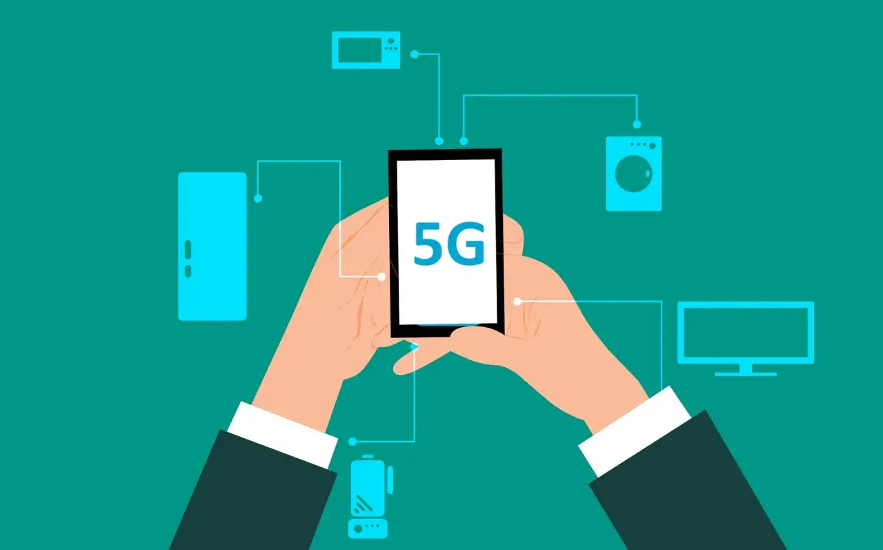 Dłonie trzymają smartfon z napisem 5G, połączony z różnymi urządzeniami domowymi. To pokazuje, co to jest 5G – przyszłość łączności.