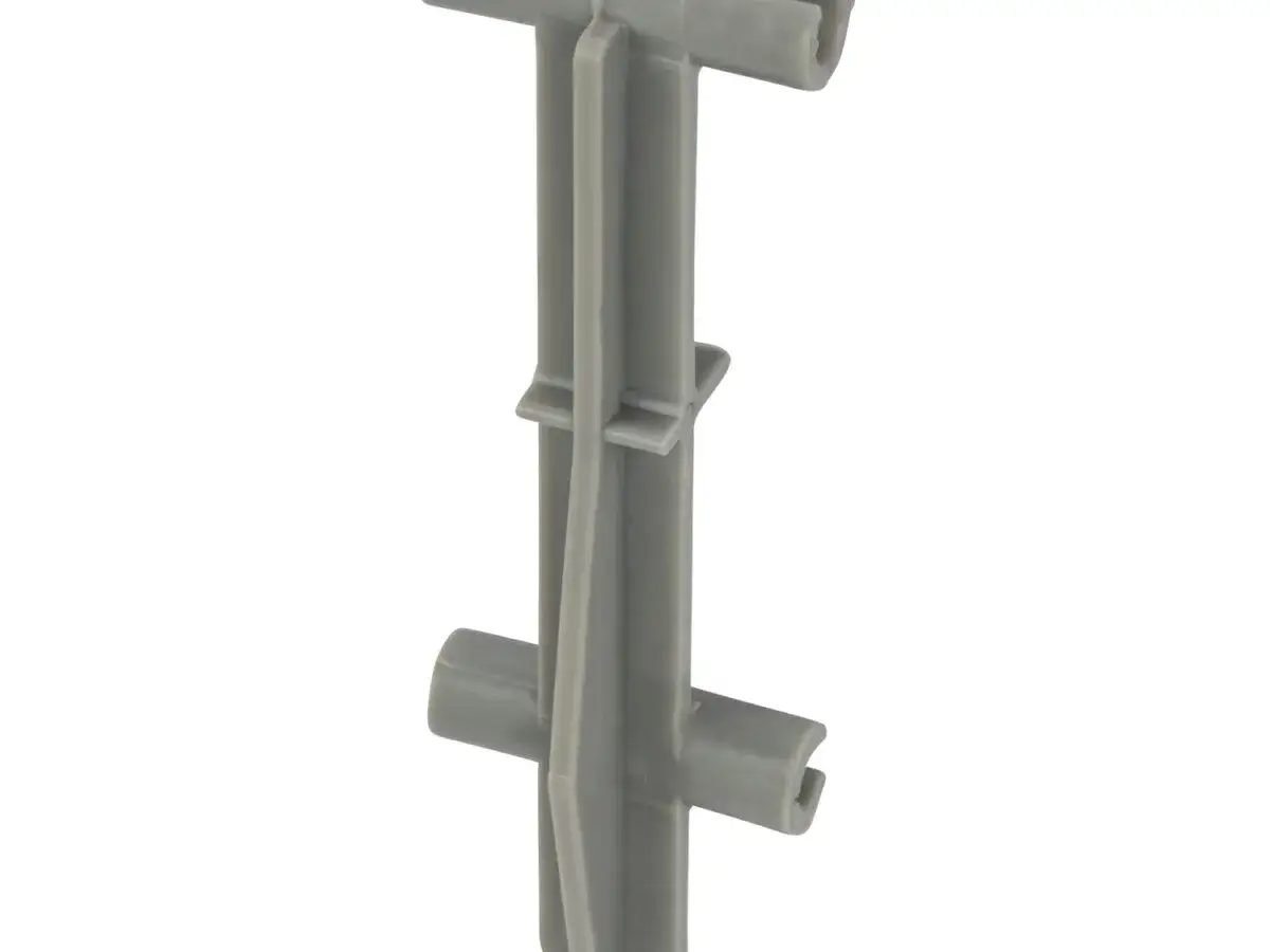 Szary plastikowy element, jeden z dystansów do zbrojenia, z dwoma poprzecznymi ramionami.