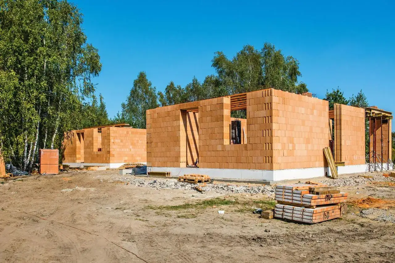 Budowa domu murowanego z pustaków ceramicznych. Widać fundamenty i wznoszone ściany.