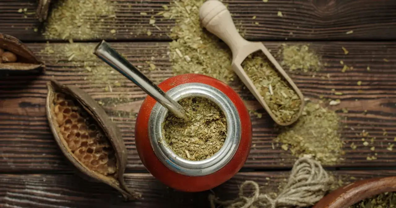 Naczynie z yerba mate, bombilla, drewniana łopatka z suszem. Choć yerba mate ma wiele zalet, warto pamiętać o jej negatywnych właściwościach.