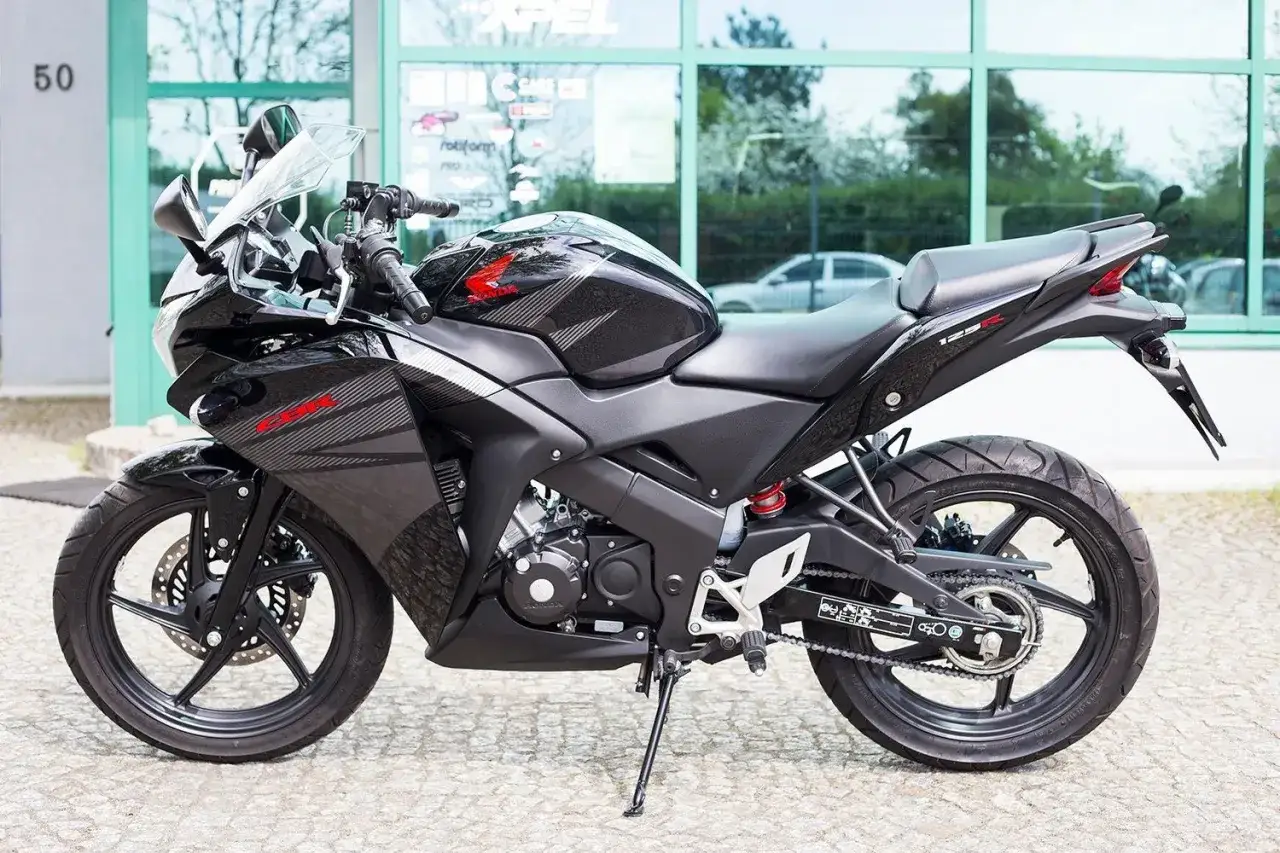 Czarny motocykl Honda CBR 125R z automatyczną skrzynią biegów, gotowy do jazdy po mieście.