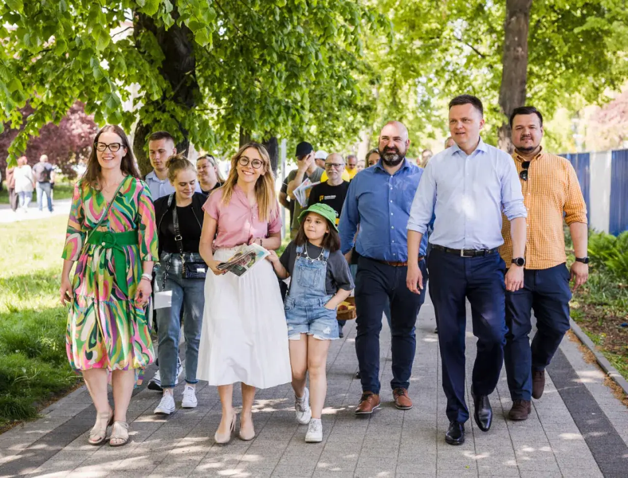 Grupa osób idzie chodnikiem. Wśród nich liderzy Polski 2050, którzy realizują obietnice wyborcze.