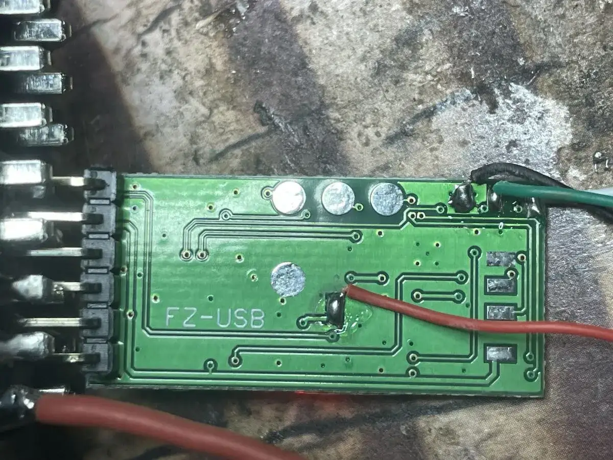 Zielona płytka drukowana z oznaczeniem "FZ-USB", prawdopodobnie moduł ELM327. Widać przewody i złącza, gotowe do instalacji sterowniki.