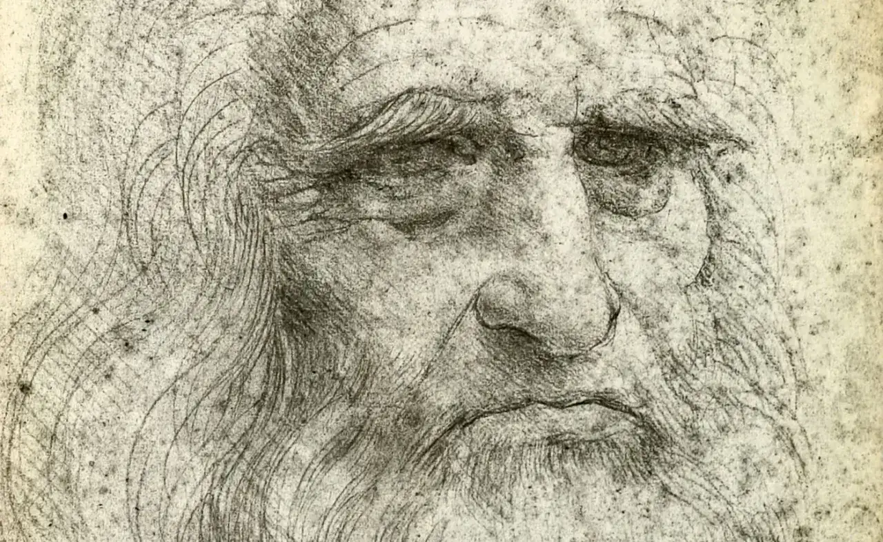 Szkic przedstawia zmęczoną twarz, prawdopodobnie autoportret Leonardo da Vinci, z charakterystyczną brodą i zmarszczkami.