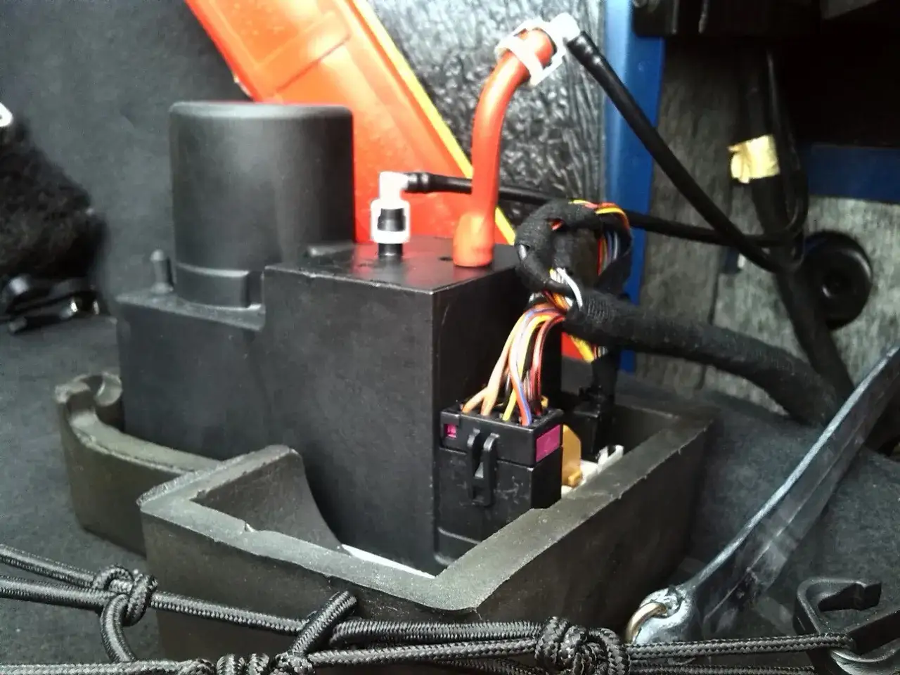 Pompka centralnego zamka Audi A4 B5 w bagażniku, z przewodami i złączami.