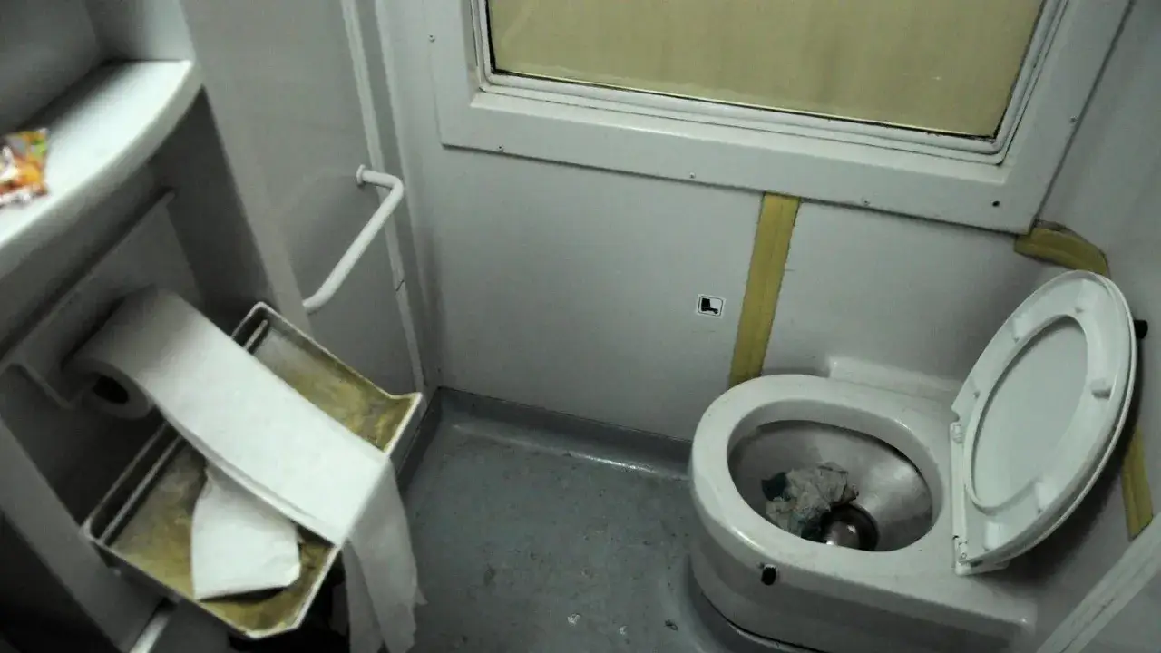 W pociągu toaleta jest w tym małym pomieszczeniu z muszlą klozetową i rolką papieru.