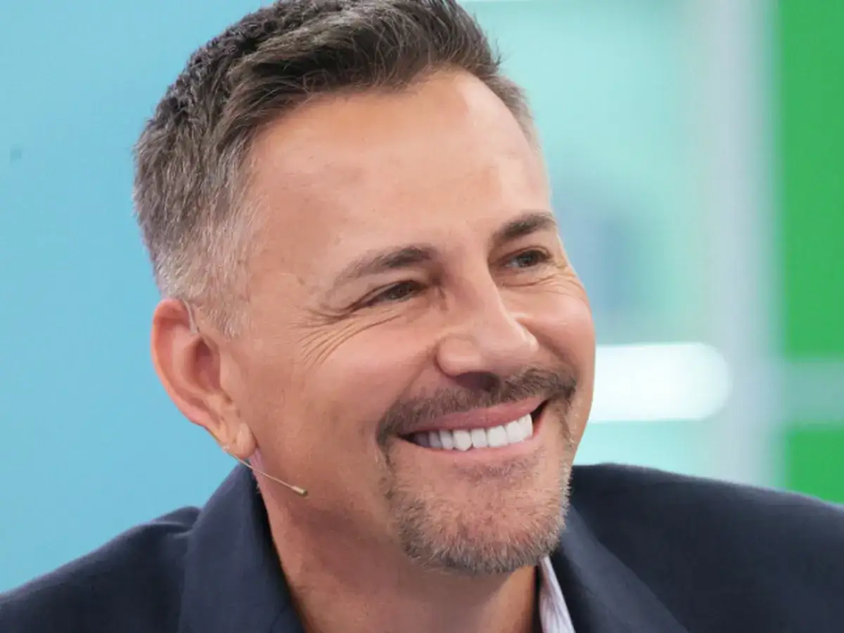 Uśmiechnięty Krzysztof Ibisz, którego wiek jest często przedmiotem dyskusji, w garniturze.