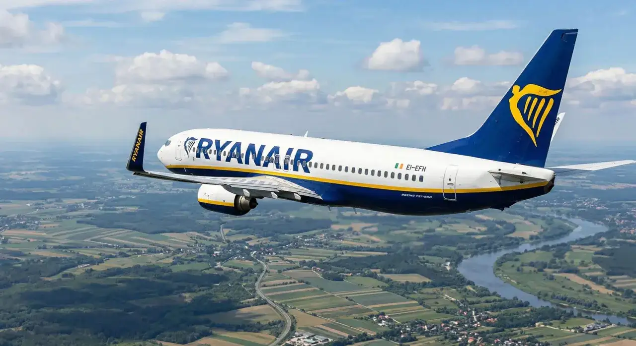Samolot Ryanair leci nad zieloną krainą. Od kiedy loty tanich linii lotniczych stały się tak popularne?
