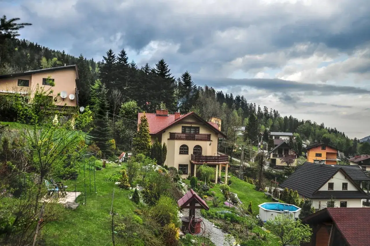 Willa Wierchy Szczyrk, malowniczo położona na zboczu, otoczona zielenią i innymi domami.