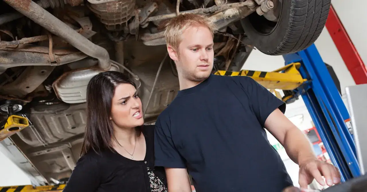 Zirytowana klientka pyta mechanika o ukryte przyczyny dla których każe płacić za diagnostykę komputerową dwa razy.