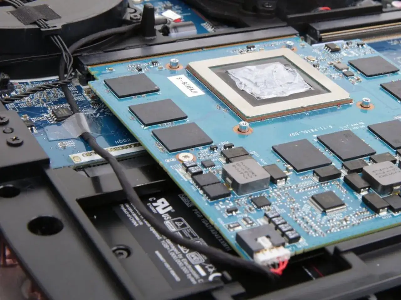 Gdzie jest karta graficzna w laptopie? Widoczny jest główny układ graficzny na niebieskiej płycie, otoczony czarnymi kośćmi pamięci RAM.