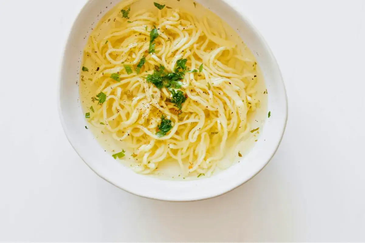 Miseczka z bulionem i makaronem, posypana natką. Czy maggi jest zdrowe? To pytanie nurtuje wielu.