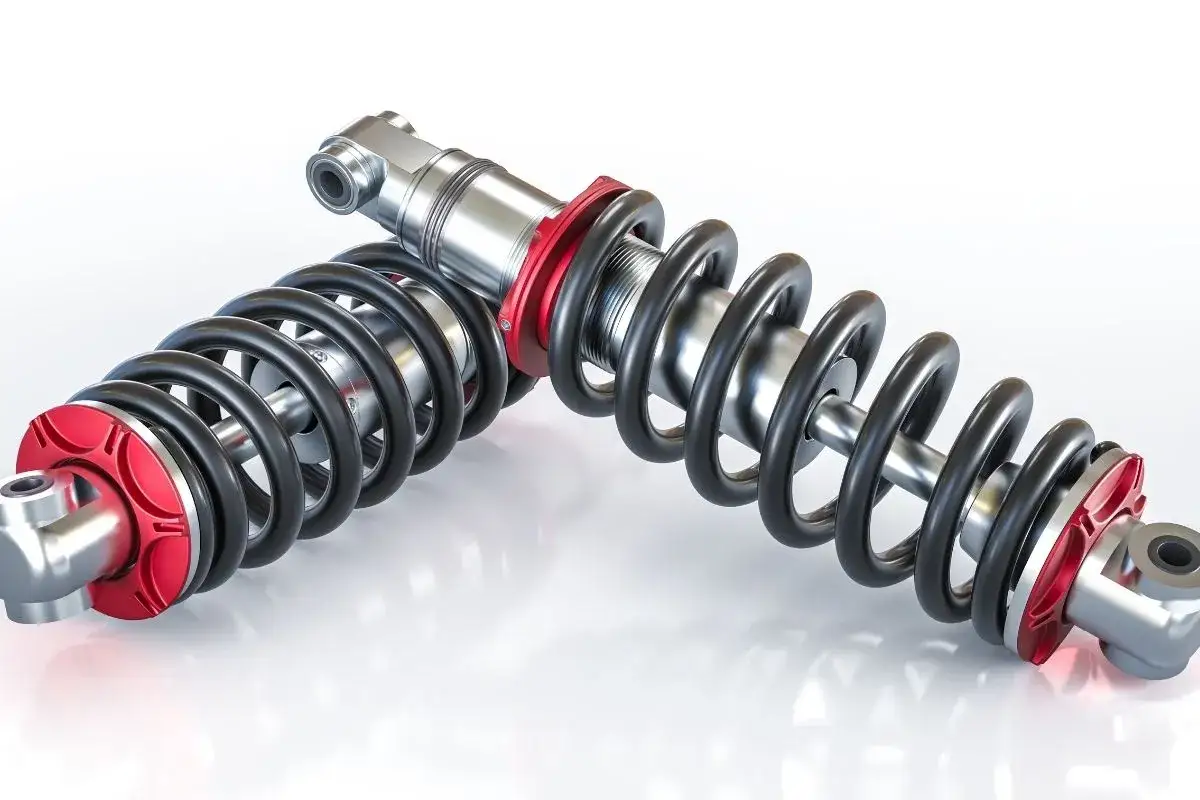 Dwa amortyzatory z czerwonymi elementami. Po wymianie amortyzatorów warto sprawdzić zbieżność, by zapewnić optymalne prowadzenie pojazdu.