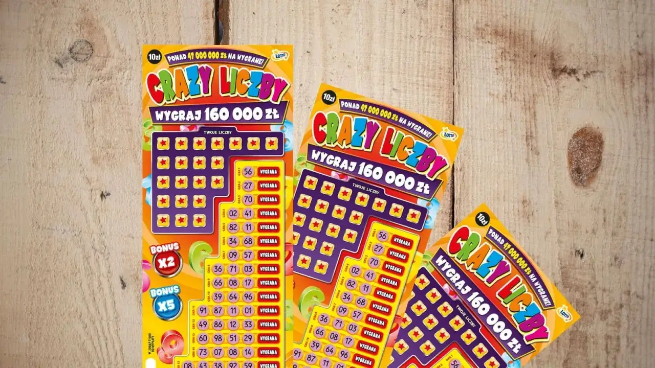 Trzy zdrapki "Crazy Liczby" leżą na drewnianym blacie. Szukasz, gdzie są litery kontrolne w zdrapkach? Tutaj ich nie znajdziesz, bo to zdrapki z liczbami.