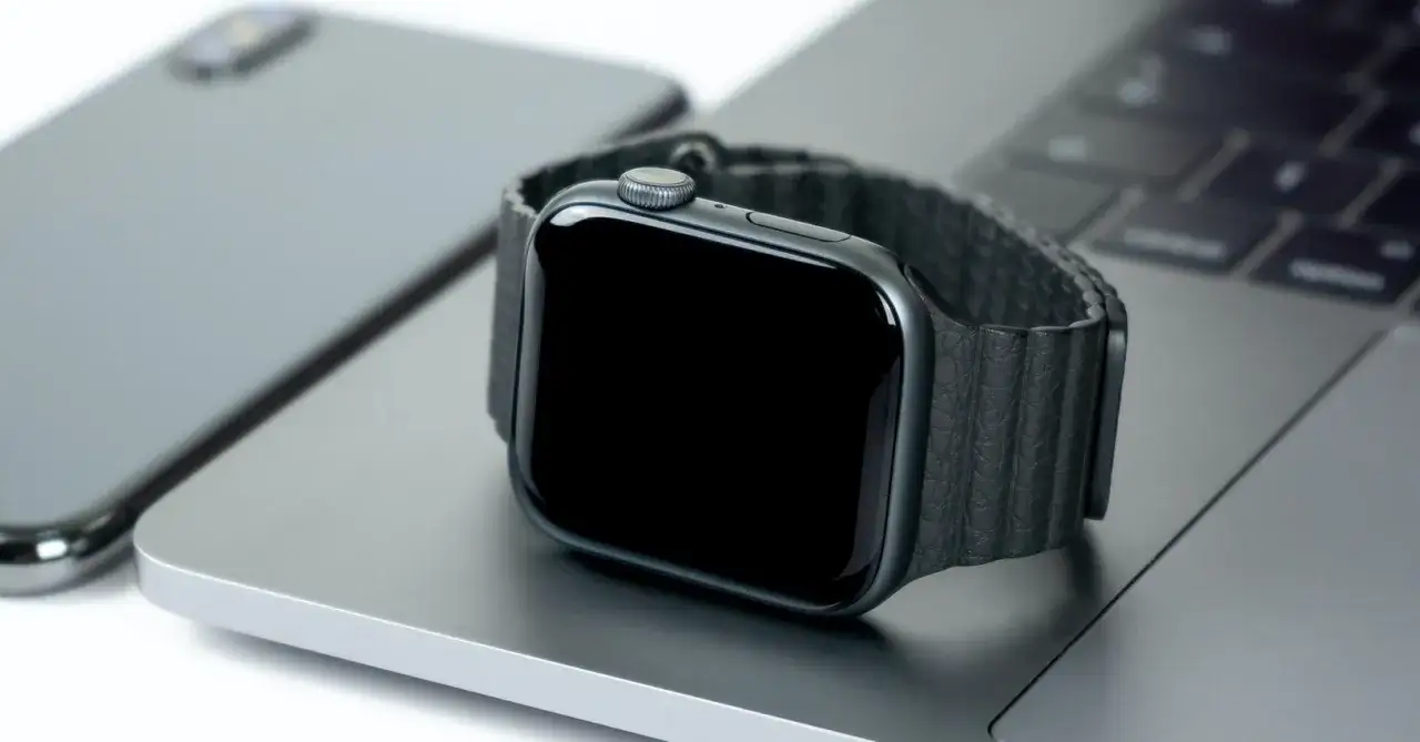 Smartwatch nie działa wyświetlacz. Czarny ekran zegarka na tle laptopa i telefonu.