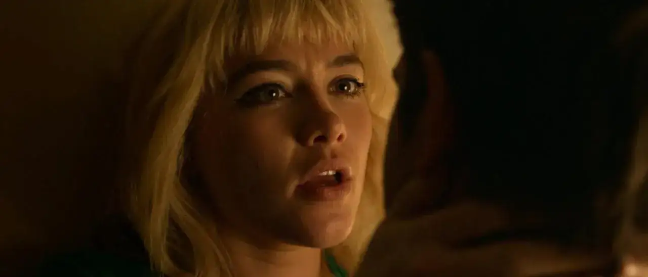 Zbliżenie na Florence Pugh w jednym z jej filmów. Aktorka ma blond włosy i intensywne spojrzenie.