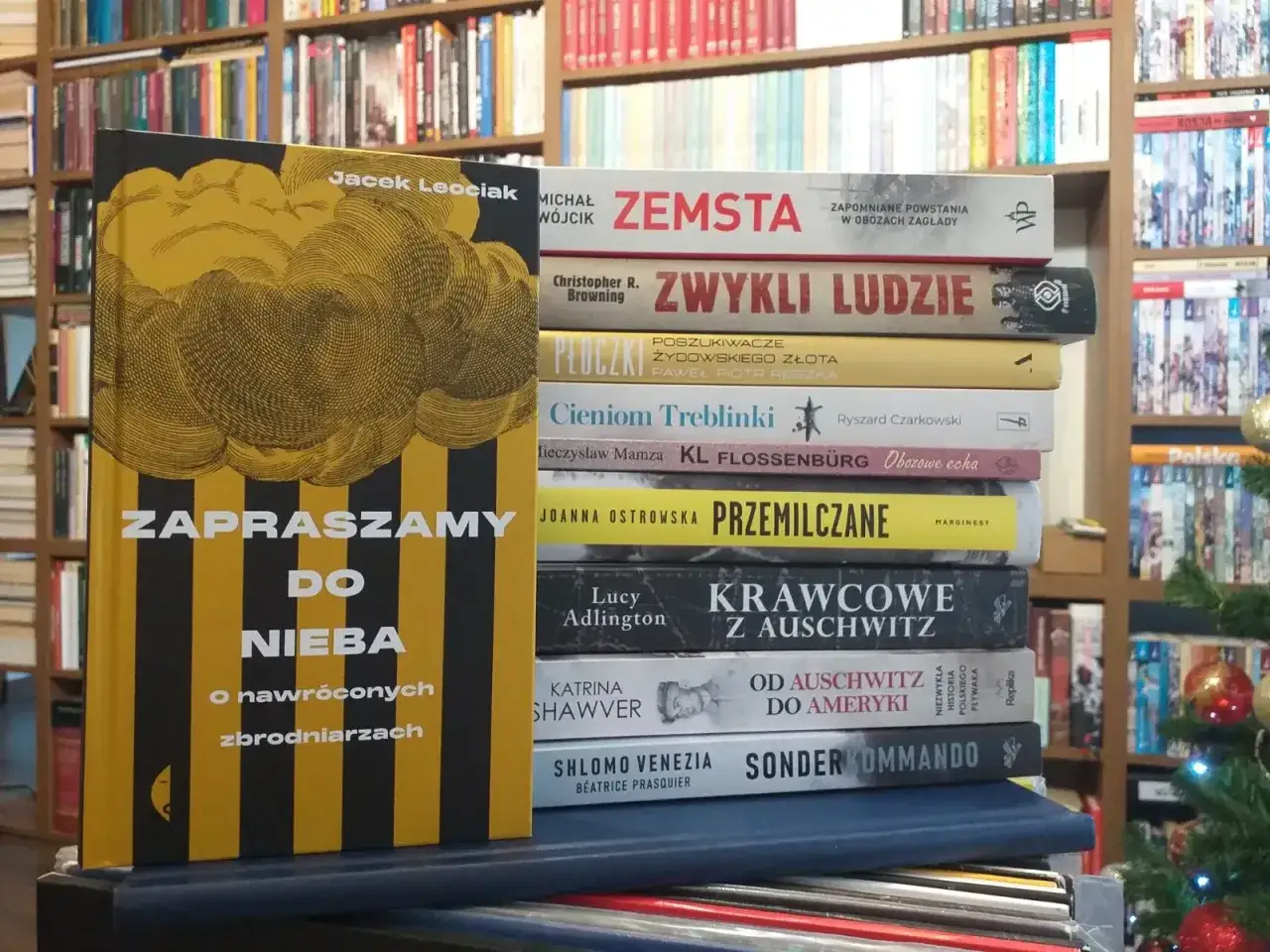Książka "Zapraszamy do nieba" o nawróconych zbrodniarzach obok innych tytułów o obozach koncentracyjnych.