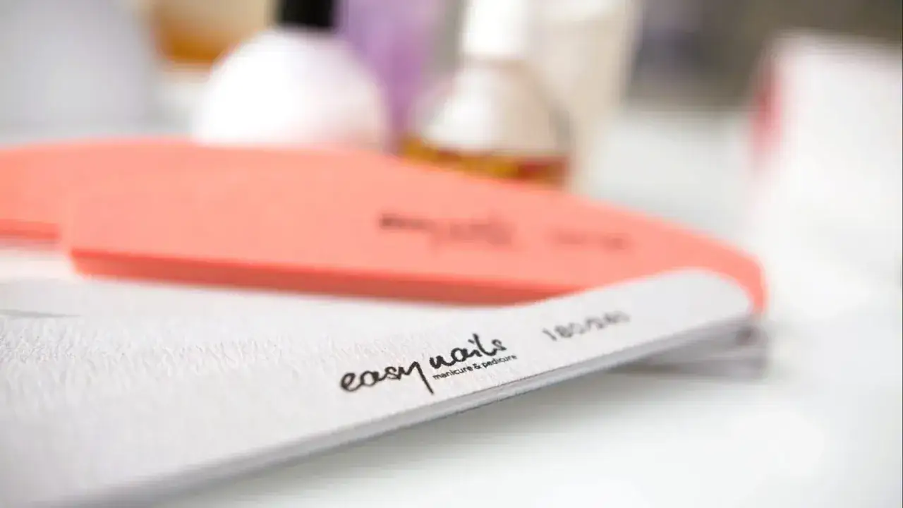 Pilniki do paznokci, jeden pomarańczowy, drugi biały z napisem "easy nails manicure & pedicure". Idealne do wykonania japońskiego pedicure.